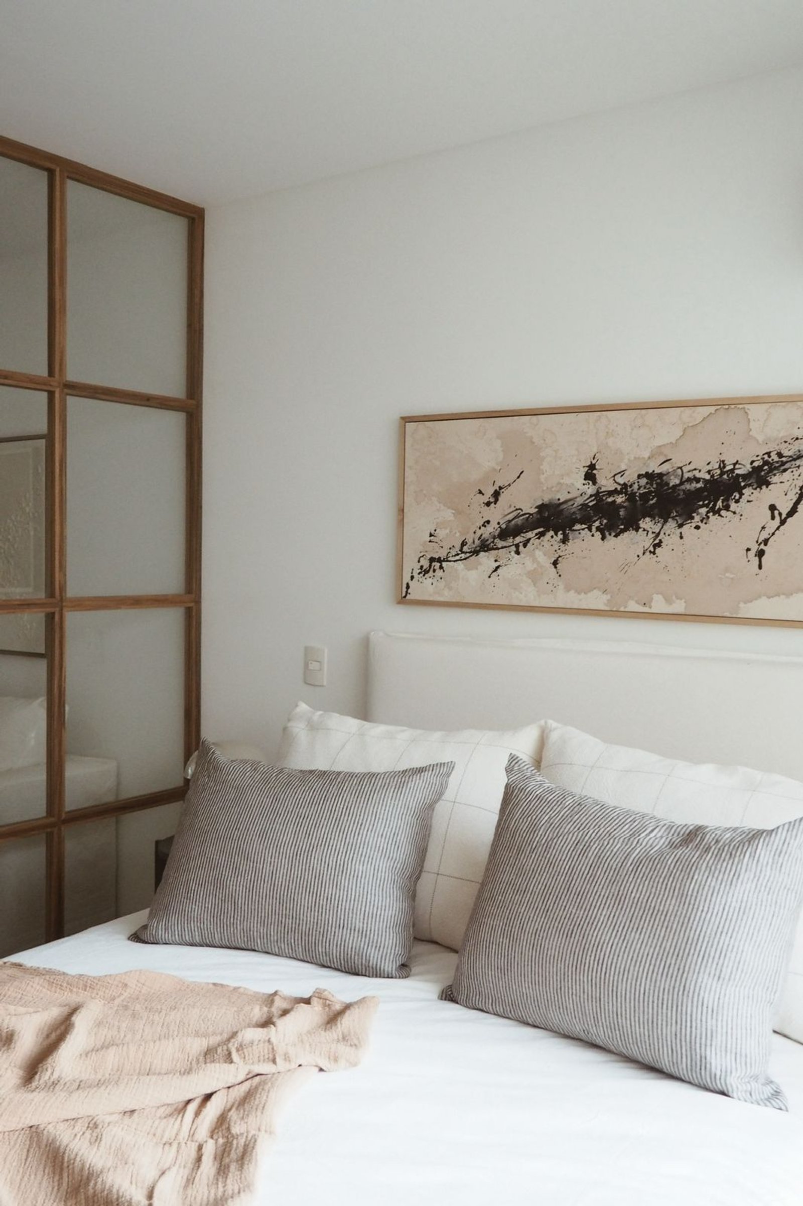 Dormitorio moderno con obra abstracta y divisor de madera y vidrio — proyecto MIGUELETES, por APATHEIA, en Buenos Aires